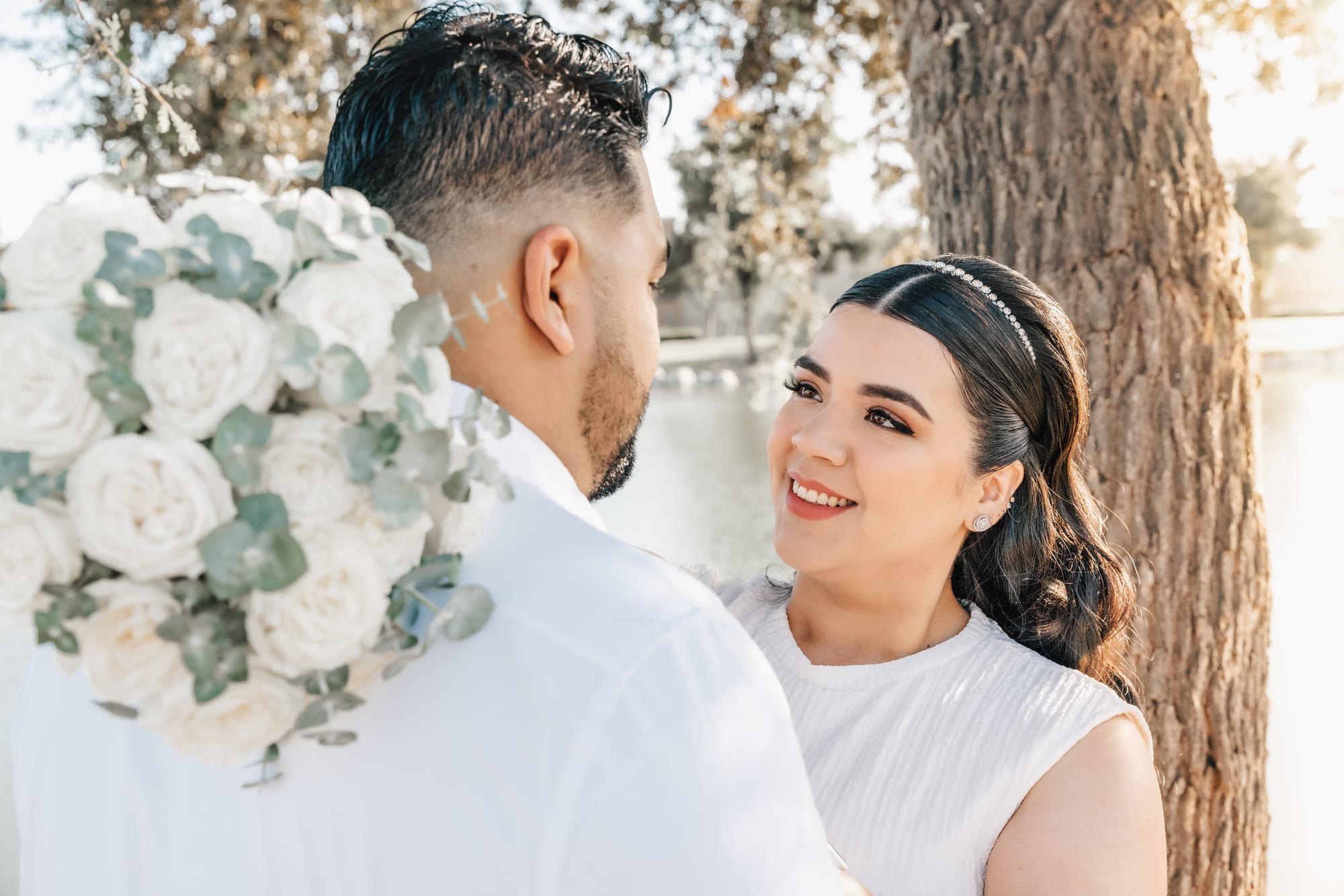 Bride smiling over her shoulder with bouquet detail