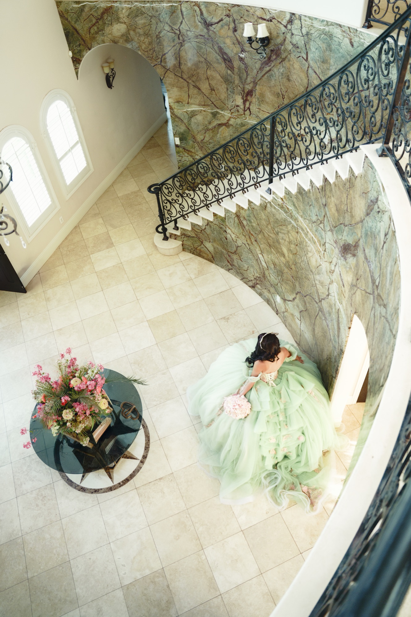 Quinceañera walking through a grand staircase entryway