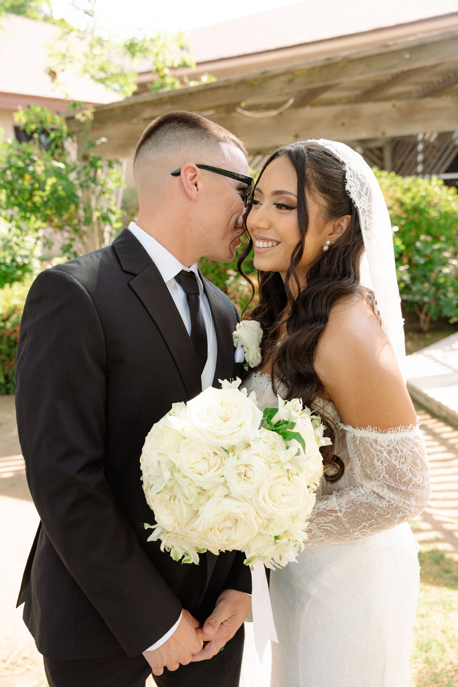Bride and groom smiling together with white bouquet